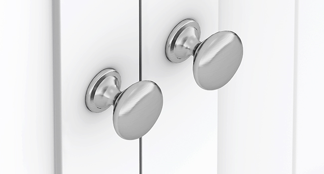 Zwei runde, gebürstete Metallgehäuseknöpfe, die auf weißen Oberflächen montiert sind. Präsentiert ein elegantes, modernes Hardware-Design für Möbel oder