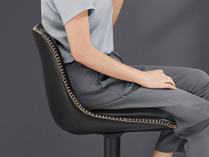 Fekete irodai szék szegecses részletekkel és ergonomikus kialakítással. Az ülő személy helyes testtartást tart fenn, a kéz a karfán nyugszik.