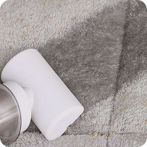 a gray carpet with a white cup on it.