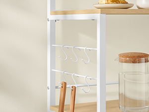 Weißes Metallregal mit mehreren Ebenen zur Aufbewahrung. Mit Haken zum Aufhängen von Gegenständen und durchsichtigen Glasbehältern mit Holzdeckeln zur Organisation